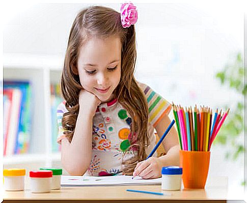 Right-handed or left-handed, girl painting with crayons