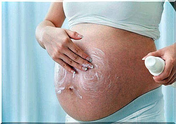 pregnant woman applying moisturizer on her belly