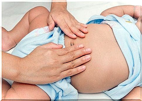 mother caressing baby's belly with abdominal pain 