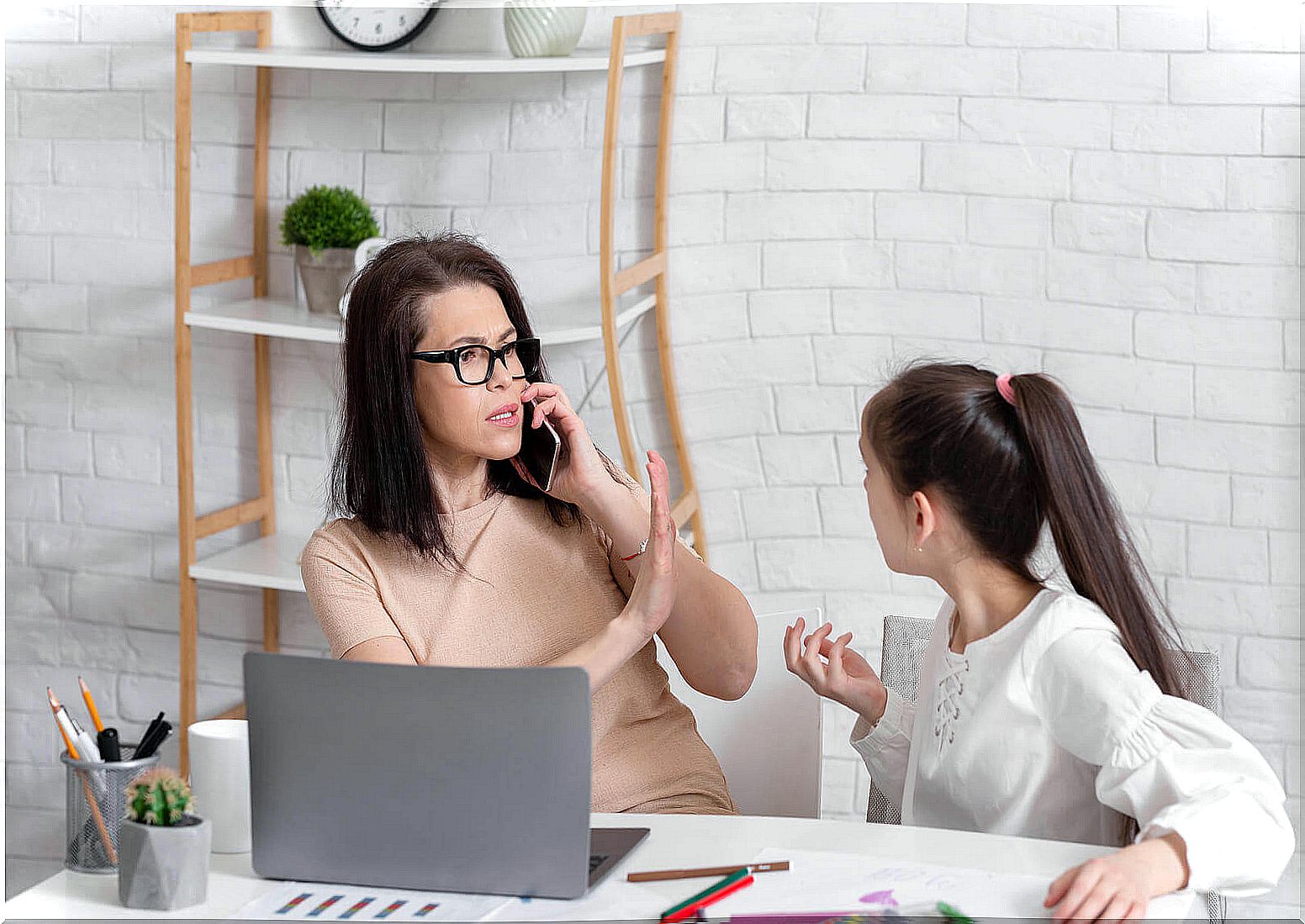 A mother working while making her daughter wait because she doesn't want to learn to delegate.